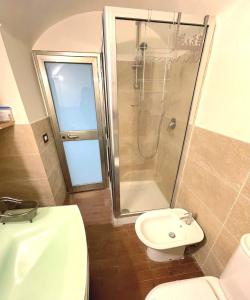 een badkamer met een douche, een toilet en een wastafel bij May's Apartment in Catania