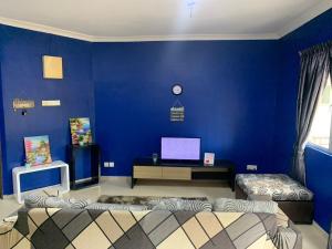 a blue room with two beds and a desk at Desaru Homestay Southern, Tiara Desaru Seaview Residensi in Bandar Penawar