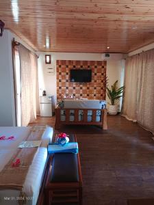 a living room with a bed and a tv on a wall at La Digue Luxury Beach & Spa in La Digue