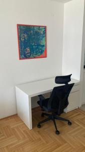 a desk with a chair and a painting on a wall at Apartman Senjak in Pirot