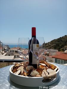 um prato de comida com uma garrafa de vinho e copos em Happy Days em Agia Galini