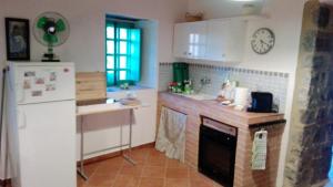 a kitchen with a brick fireplace and a refrigerator at Giro di vite in Rocca Imperiale