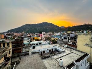 Blick auf eine Stadt mit Sonnenuntergang im Hintergrund in der Unterkunft Hotel The Mantra , Haridwar in Haridwar