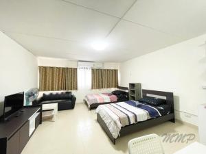 a bedroom with two beds and a desk and a couch at Popular The best muangthongthani 日常房间公寓 in Ban Bang Phang
