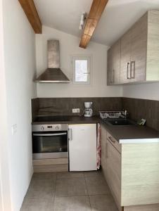 une cuisine avec une cuisinière et un évier dans l'établissement Appartement bord de mer 2 personnes, à Sagone