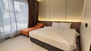 um quarto com uma cama grande e uma cadeira em Urban Inn, Salak Tinggi em Sepang
