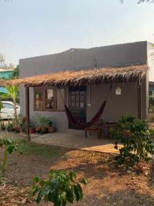 una pequeña casa con una hamaca delante en ใจแปงโฮมสเตย์ Jaipang Homestay, en Pai