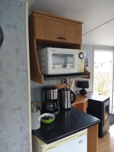 a kitchen with a counter top with a microwave at De Veenborg in Kolham