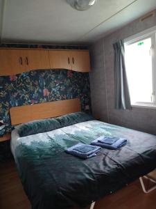 ein Schlafzimmer mit einem Bett mit zwei Handtüchern darauf in der Unterkunft De Veenborg in Kolham