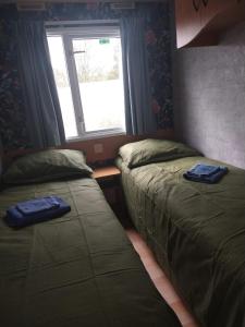 2 Betten in einem kleinen Zimmer mit Fenster in der Unterkunft De Veenborg in Kolham