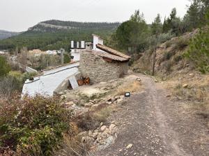 un edificio al lado de una carretera junto a un río en Casa Rural La Garcia, en La Pobla d'Arenós (Puebla de Arenoso)