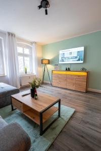 sala de estar con mesa de centro y TV de pantalla plana en Luxury Vista Apartment I Küche I WLAN I Smart-TV, en Magdeburgo