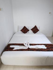 a white bed with two white towels on it at Jogja Amor Hotel in Yogyakarta +43 photos