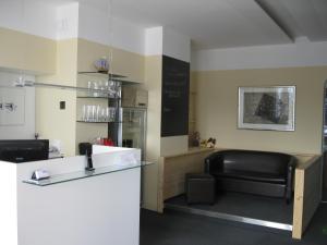 a waiting room with a counter and a chair at Hotel & Fitness Castello in Seewalchen