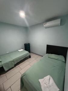 a room with two beds and a air conditioner at Casa Tabacon cr in Río Claro