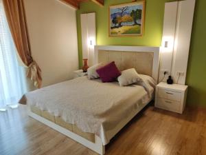 sypialnia z dużym łóżkiem z 2 szafkami nocnymi i awrtisement w obiekcie Hotel & Restaurant White City w mieście Berat