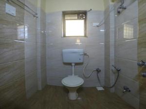 a bathroom with a toilet and a shower with a window at Hotel classic residency in Mumbai