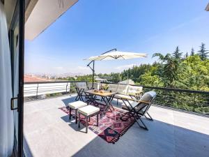 une terrasse avec une table, des chaises et un parasol dans l'établissement 113 - Cozy,City View,Lux,Relax, à Ankara