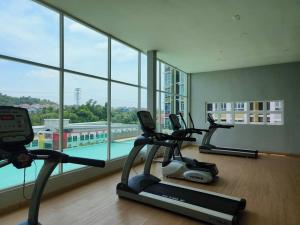a gym with three exercise bikes in a room with windows at LV13 PoolView Kuantan by Vhomestay in Kuantan
