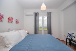 Un dormitorio con una cama azul y una ventana en Villa Zoi, en Méson Yerakaríon