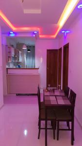 ein Esszimmer mit einem Tisch und violetten Lichtern in der Unterkunft Luxueux Appartement F3 in Dakar