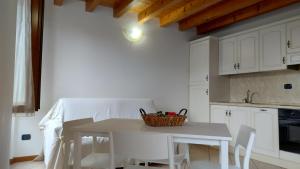 a white kitchen with a white table and chairs at B&B Agora' in Gardone Riviera