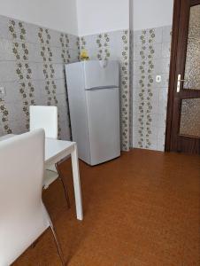 frigorifero bianco in una stanza con tavolo e sedie di Intero appartamento nel cuore di Maiori a Maiori