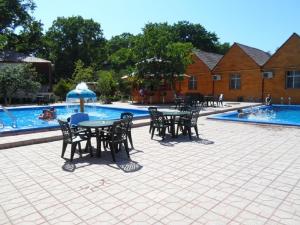 a patio with tables and chairs next to a swimming pool at Hotel Bulaq in Turist