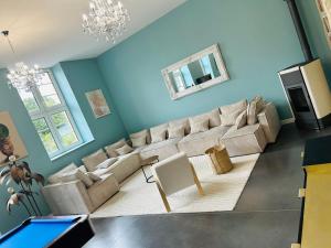 a living room with a couch and a tv at Hôtel Déco'lia-Soirée étape in Ballon