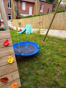 un patio trasero con una cama elástica en el césped en Maison de vacances familiale à Trouville-sur-mer, en Trouville-sur-Mer