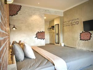 uma cama grande num quarto com uma parede de tijolos em the AMARTYA em Yogyakarta