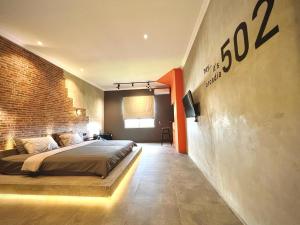 um quarto com uma cama e uma parede de tijolos em the AMARTYA em Yogyakarta