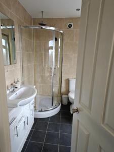 a bathroom with a shower and a sink and a toilet at 4 Bedroom Equipped House Driveway- 10 Mins to NEC JLR BHX HS2 & More- Birmingham Sutton Coldfield, Coleshill & More in Solihull