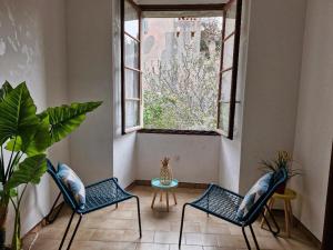two chairs and a table in a room with a window at Appartement centre Saint Florent in Saint-Florent +3 photos