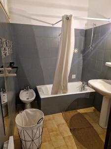La salle de bains est pourvue d'une baignoire, de toilettes et d'un lavabo. dans l'établissement Appartement centre Saint Florent, à Saint-Florent