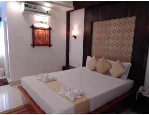 una camera da letto con un letto bianco e due asciugamani di Airport Hotel, Andaman and Nicobar Islands a Port Blair