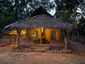 a woman standing in front of a hut at Glimra eco lodge in Hambegamuwa