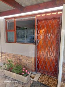 uma porta vermelha de uma casa com flores na frente em Apartment in Stellenbosch em Stellenbosch