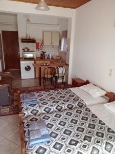 ein Schlafzimmer mit einem Bett und eine Küche mit einem Tisch in der Unterkunft STUDIO ILIANA in Samos