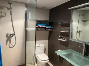 a bathroom with a shower and a toilet and a sink at Appart Duplex Roses Plage in Roses +35 photos