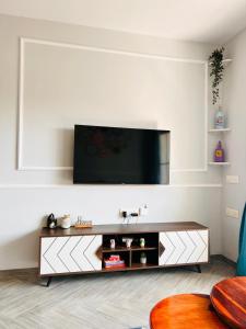カラングートにあるArtistic ZenZone 1BHK near Calangute Beach - North Goaの壁に薄型テレビが取り付けられたリビングルーム