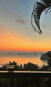 a view of the ocean at sunset from a balcony at Hillhouse - Koh Yao Noi in Ko Yao Noi