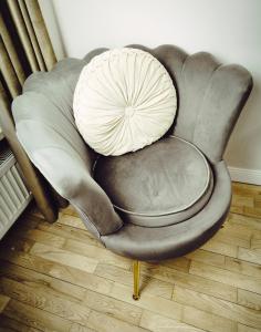 a chair with a pillow on top of it at Central Apartments Ogarna 5 in Gdańsk