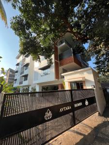 カラングートにあるArtistic ZenZone 1BHK near Calangute Beach - North Goaの白い建物の前の黒い柵