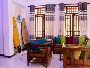 a living room with a couch and surfboards on the wall at Lighthouse Villa Koggala in Galle