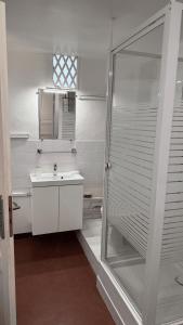 W łazience znajduje się szklana kabina prysznicowa i umywalka. w obiekcie Studio Gambetta Saint-Tropez w Saint-Tropez