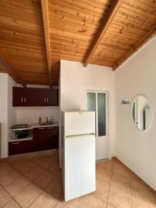 a white refrigerator in a kitchen with wooden ceilings at Evita's House in Lukovë