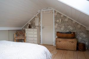 a bedroom with a white bed and a stone wall at Klara House in Isfjorden