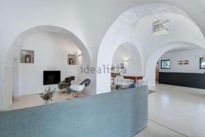 a living room with white walls and a blue counter at Villa Monika - Luxury Trulli Resort in Locorotondo