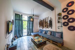 a living room with a blue couch and a table at Loft Style Apartment in Tbilisi City +11 photos